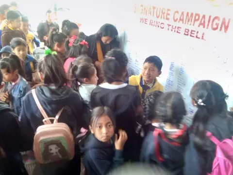 Various school students signing on the Signature Campaign for 'Ring the Bell' activity for RAISE-NE.