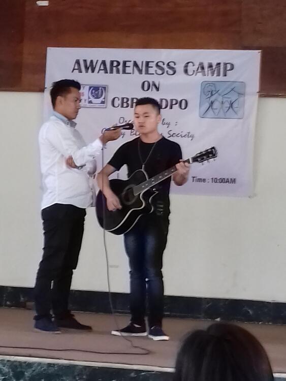 A visually impaired boy playing a guitar